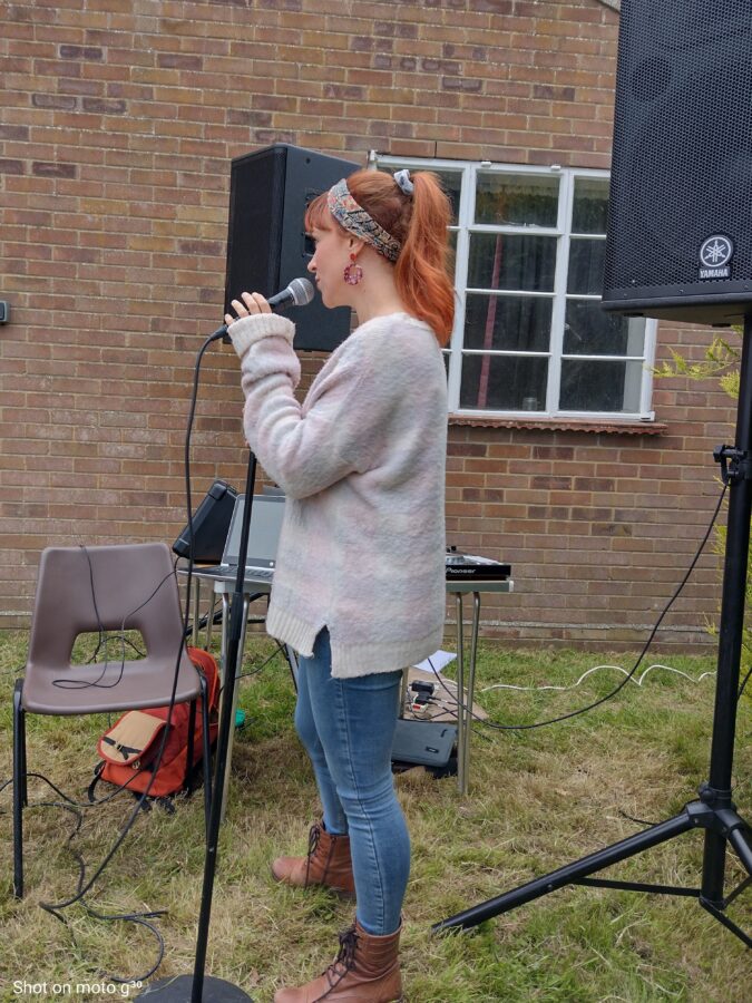 The photo shows singing into a microphone.